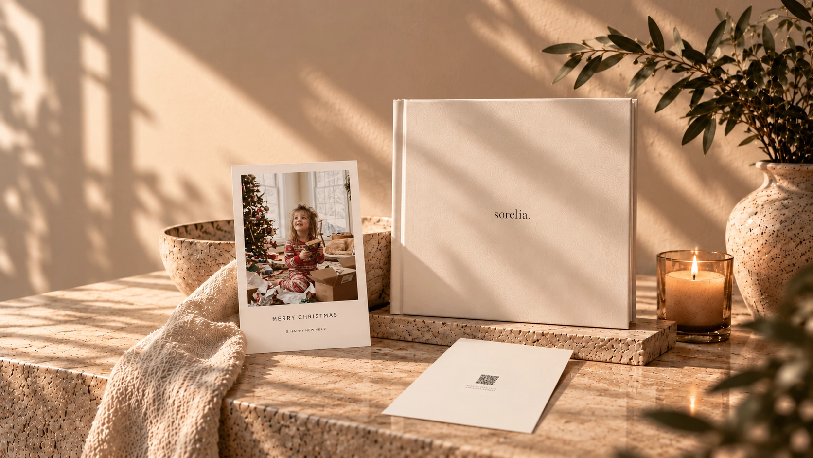 Illustrative Christmas postcard with a child opening gifts, cream keepsake book and unsigned QR-bearing reverse in warm sunlight